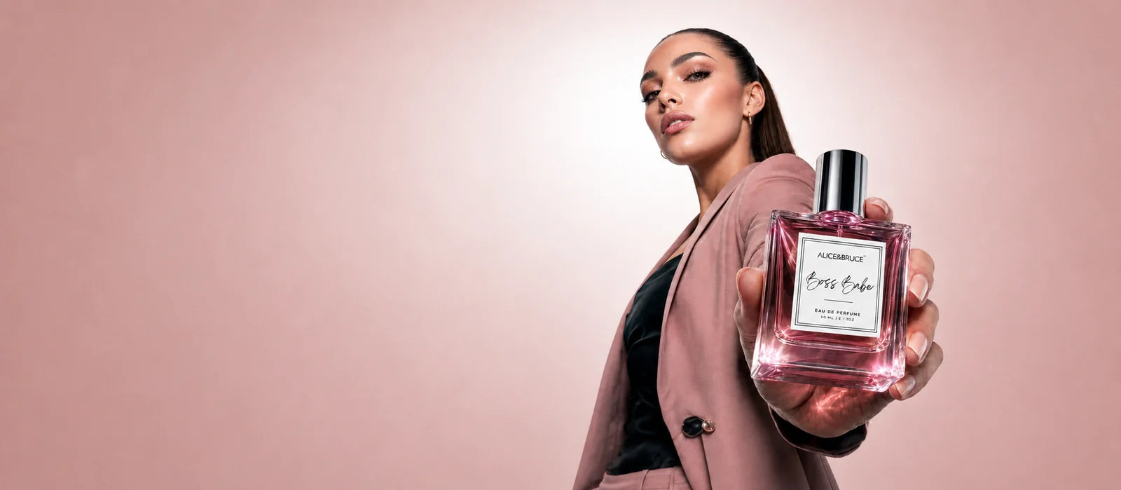 Woman holding Alice and Bruce Boss Babe luxury perfume bottle in an elegant fashion portrait