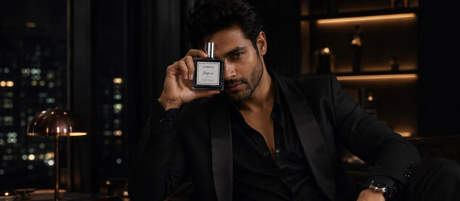 Man in black suit holding Alice and Bruce Magnus luxury perfume in a dark elegant lounge setting